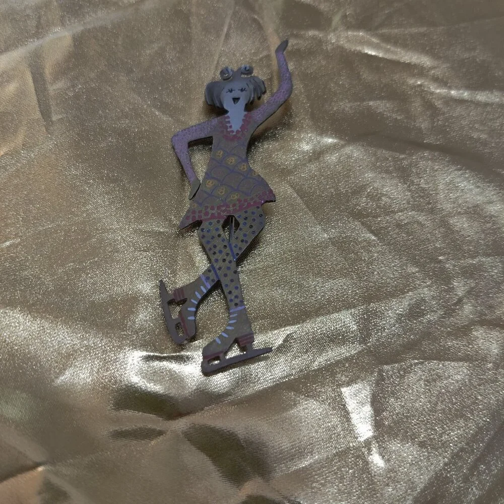 Brooch of a whimsical girl Figure Skater. Signed GB.
